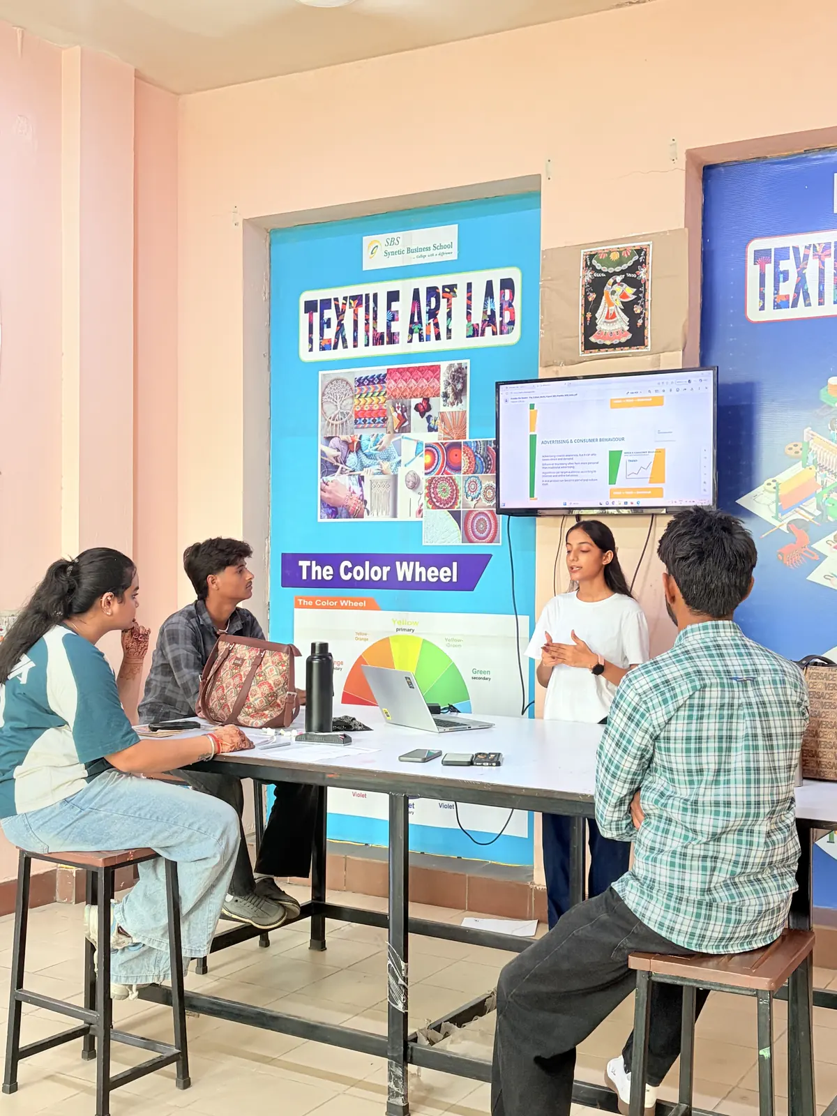 Textile Designing student presenting in the SBS Textile Art Lab beside a colour wheel display