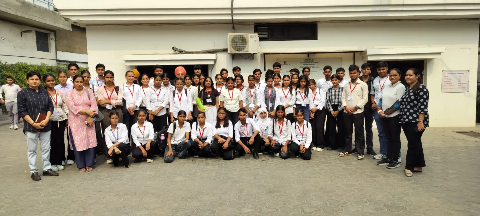 B.Sc Textile first-year students and faculty wearing red ID lanyards posing for a group photo outside the Versatile Enterprises premises
